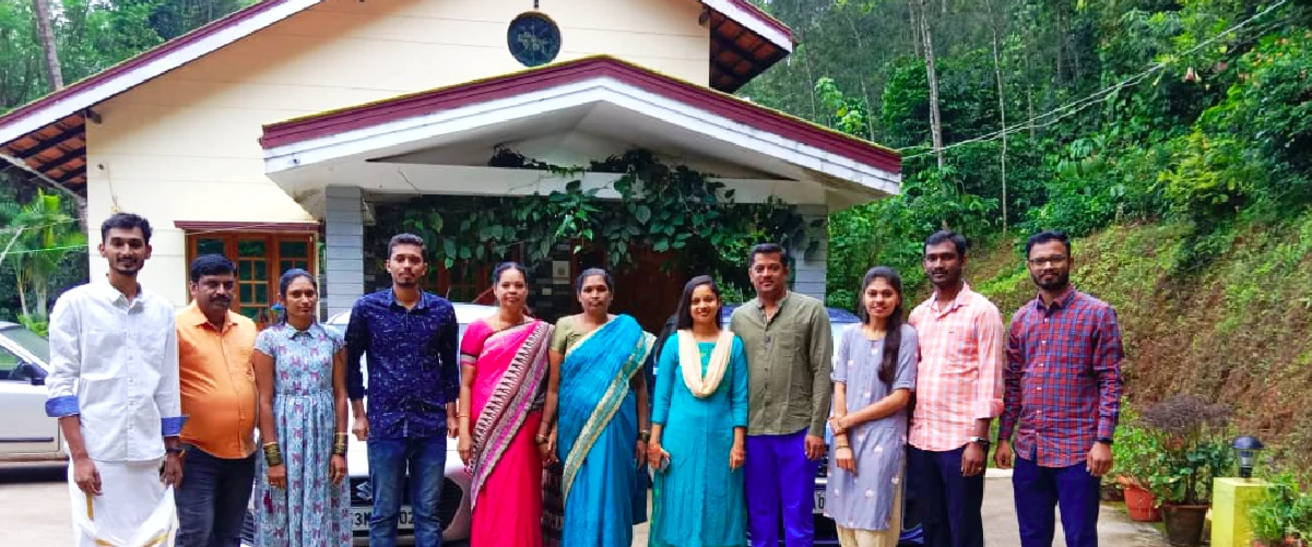 Family group posing in front of homestay in chikmagalur